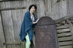 Ewa Krychniak et la stèle funéraire juive qu'elle a pu sauver et qui était utilisée comme établi par un menuisier